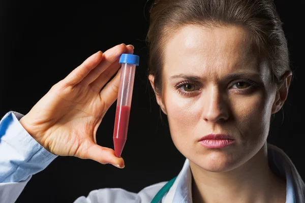 Medico donna mostrando provetta isolato su nero — Foto Stock