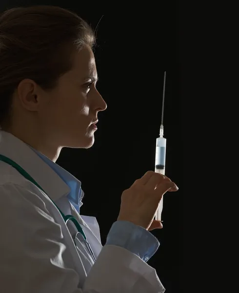 Silhouette of doctor woman with syringe on black background — Stock Photo, Image