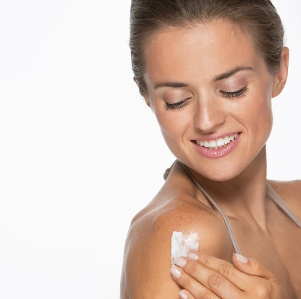 Donna felice applicando crema sulla spalla — Foto Stock