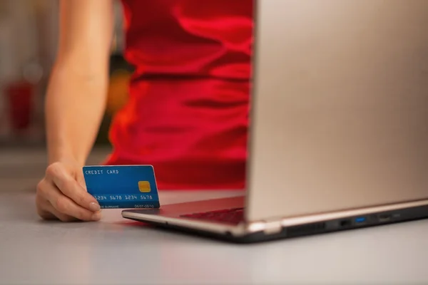 Primer plano en la tarjeta de crédito en la mano de la mujer haciendo compras en línea — Foto de Stock