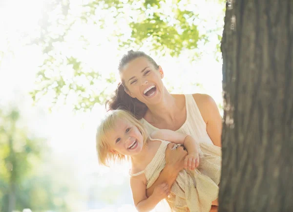 Gelukkig moeder en baby uitkijken van boom — Stockfoto