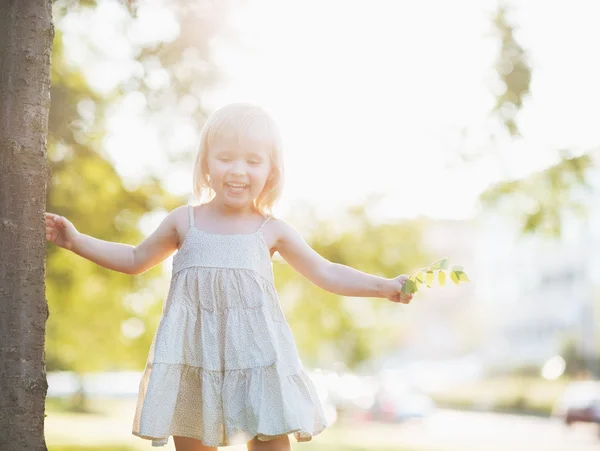 Portrét happy baby girl v městském parku — Stock fotografie