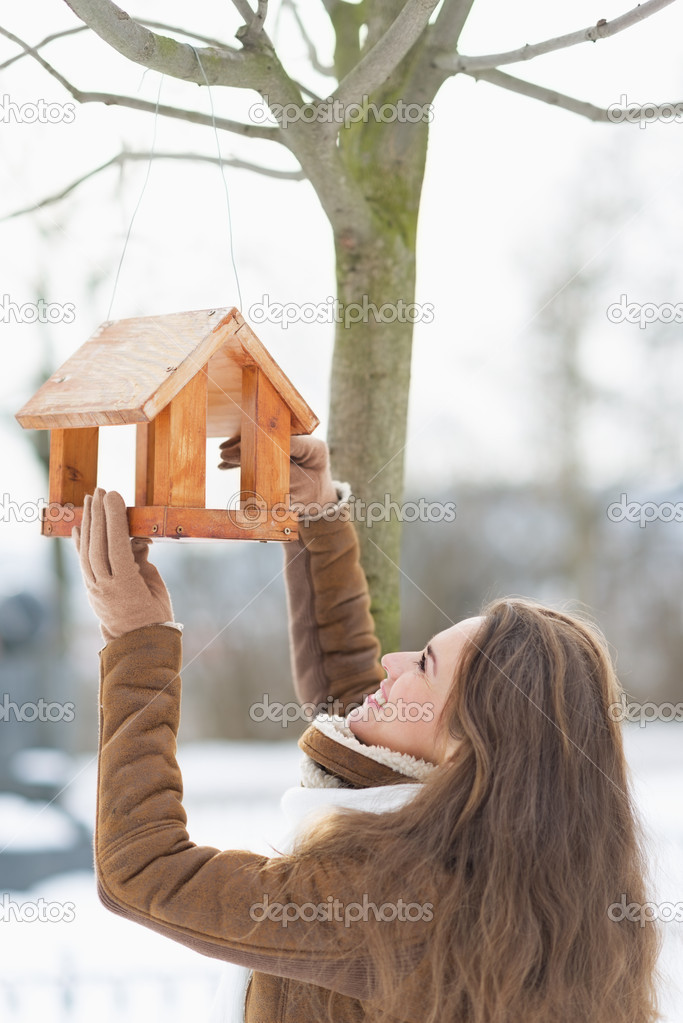 Woman standing under bird feeder