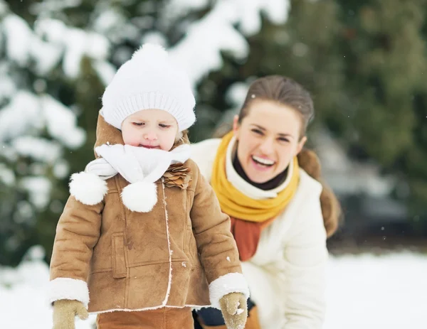 Happy mother and baby playing in winter outdoors — Stock Photo, Image