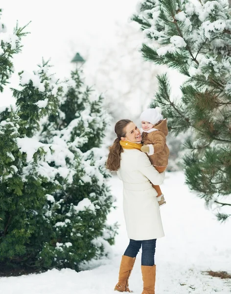 Lycklig mor och barn gå i Vinterparken — Stockfoto