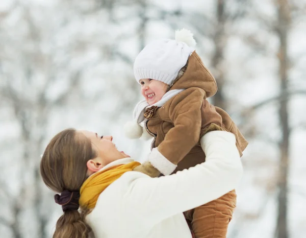 Glad mamma leker med baby i vinter utomhus — Stockfoto