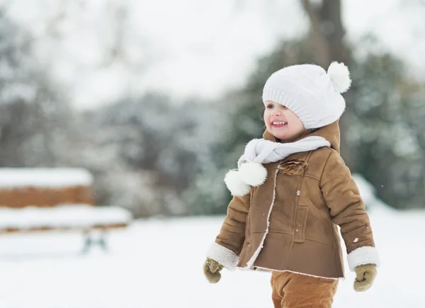 Portrait of smiling baby in winter park — Stock Photo, Image