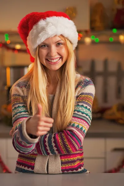 Usmívající se dospívající dívka v santa hat ukazuje palec — Stock fotografie