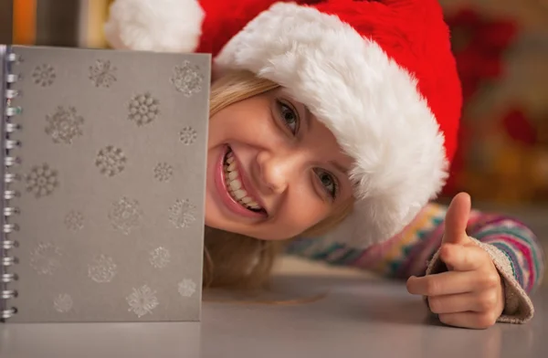 Portret van lachende tienermeisje in Kerstman hoed op zoek uit dagboek — Stockfoto