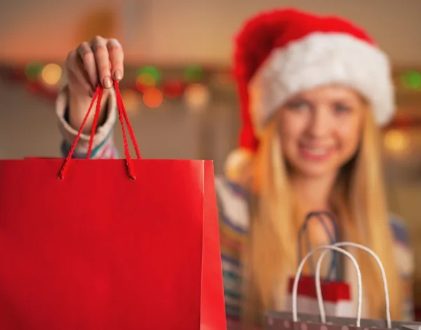 Close-up op lachende tienermeisje in Kerstman hoed tonen boodschappentas — Stockfoto