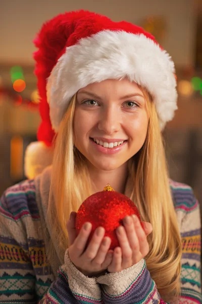 Retrato de menina adolescente feliz em santa chapéu segurando bola de Natal — Fotografia de Stock
