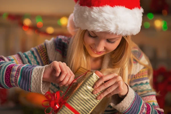 Happy teenage girl in santa hat opening christmas present box — Stock Photo, Image