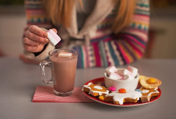 Primer plano de la adolescente poniendo malvavisco en la taza de chocolate caliente — Foto de Stock