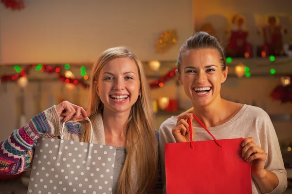Iki kız alışveriş çantası ile süslenmiş Noel içinde gülümseyen — Stok fotoğraf