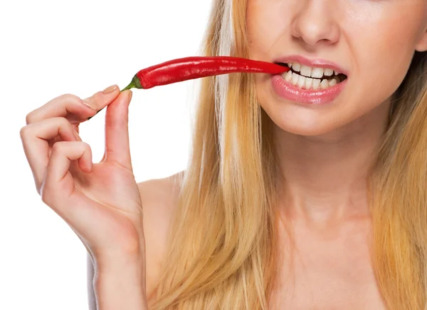 Closeup on teenage girl holding biting red chili pepper — Stock Photo, Image
