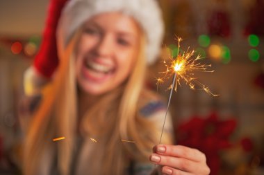 tatlı Noel Baba şapkası maytap holding gülümseyen genç kız üzerinde