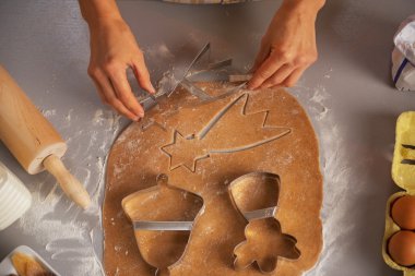 Young housewife making christmas cookies with dough cutter clipart