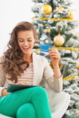 Noel ağacının yakınında tablet pc ile alışveriş online yapma kadın