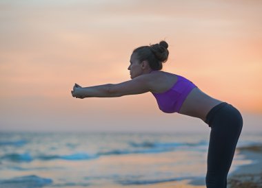 Sahilde akşamları germe fitness genç kadın