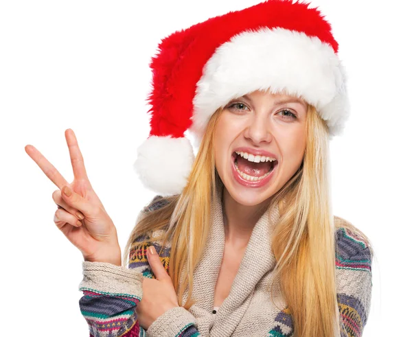 Noel Baba şapkası zafer hareket gösteren gülümseyen genç kız portresi — Stok fotoğraf