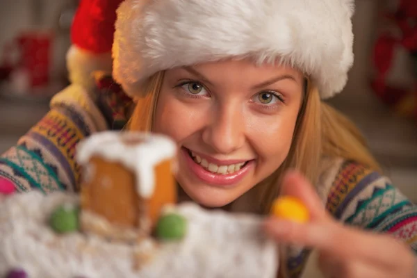 Lächelnde Teenager-Mädchen mit Weihnachtsmütze dekorieren Weihnachtsplätzchenhaus — Stockfoto