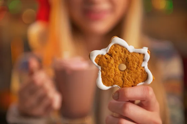 Gros plan sur adolescent fille avec tasse de chocolat chaud montrant biscuit de Noël — Photo