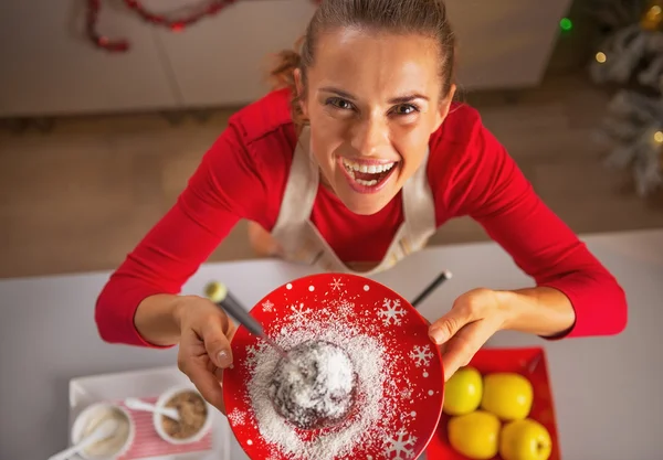 Smiling young housewife showing apple in chocolate glaze — Stock Photo, Image