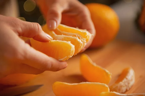 Closeup on young housewife dividing orange slices — Stock Photo, Image