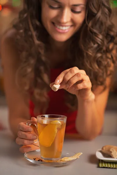 Gelukkig jonge vrouw bruine suiker kubus ingebruikneming gember thee — Stockfoto