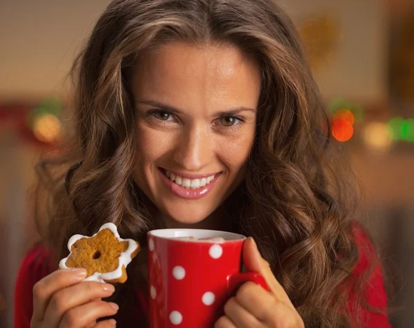 Portrait of smiling young woman with cup of hot chocolate and christmas cookie — Stock Photo, Image