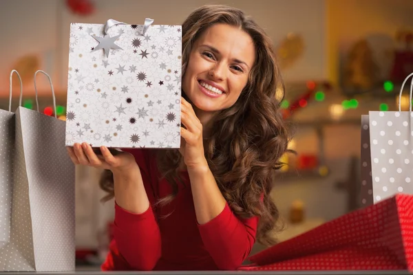 Mujer joven sonriente mostrando bolsa de compras de Navidad — Foto de Stock