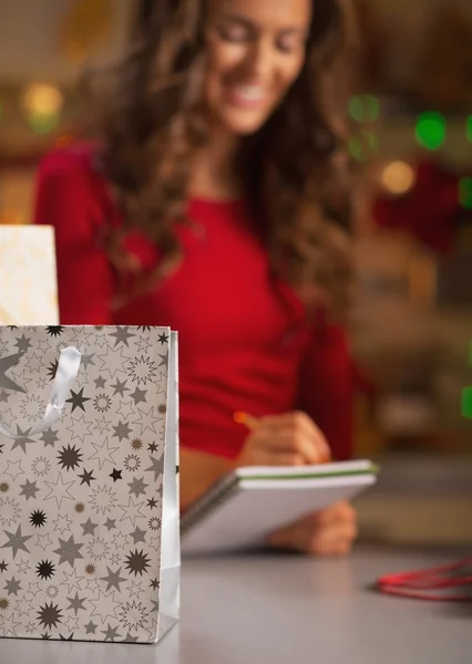 Крупним планом на різдвяній сумці і щаслива жінка перевірка списку — стокове фото
