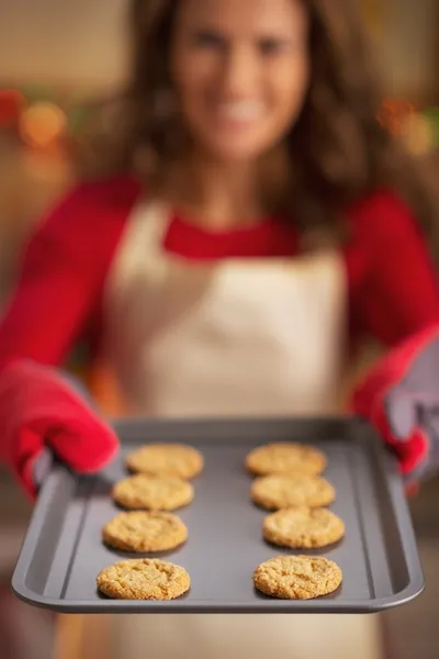 Zbliżenie na patelni z christmas cookies w ręka uśmiechający się gospodyni — Zdjęcie stockowe