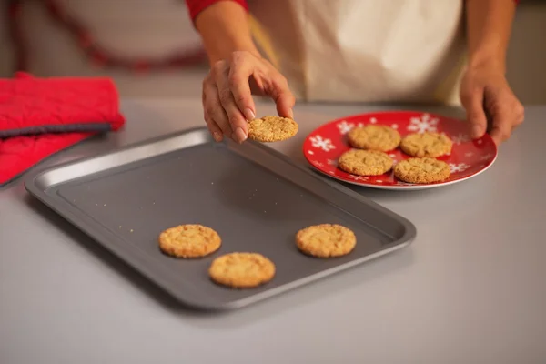 Hemmafru sätta jul cookies från pannan till tallrik — Stockfoto