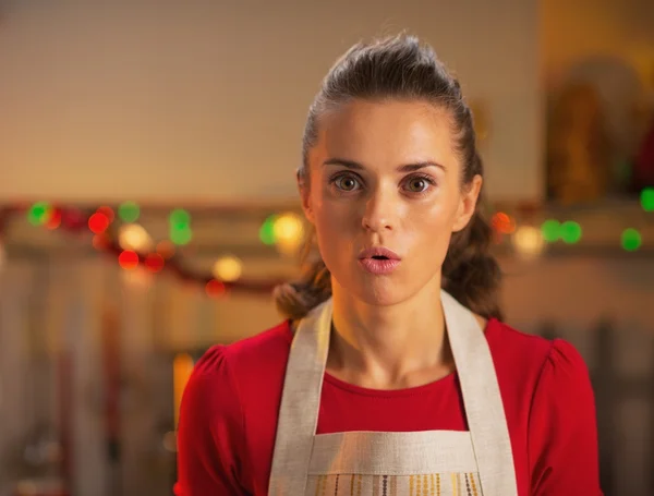 Surprised young housewife in christmas decorated kitchen — Stock Photo, Image