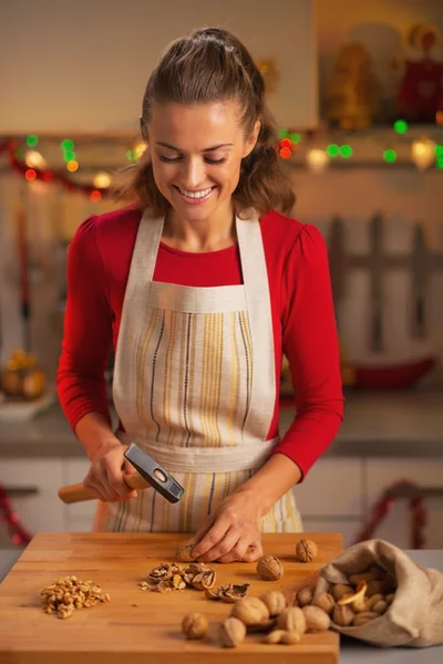 Happy young housewife chopping walnuts — Stock Photo, Image