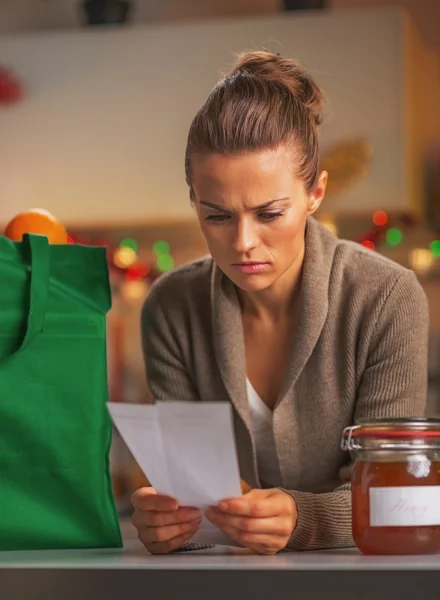 Preocupado joven ama de casa buscando cheques después de la tienda de Navidad — Foto de Stock