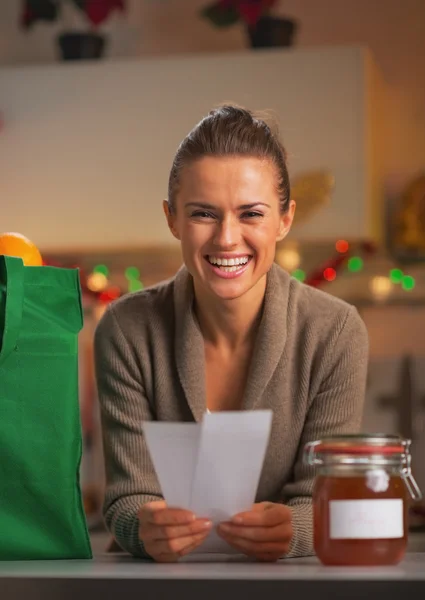 Glad ung hemmafru med kvitton från jul inköp — Stockfoto