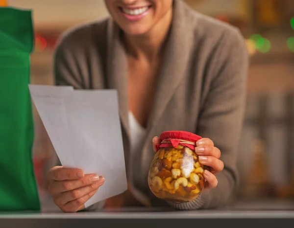 Close-up em feliz jovem dona de casa com cheques explorando natal — Fotografia de Stock