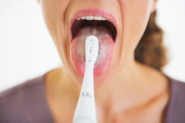 Close-up op jonge vrouw schoonmaken tong met behulp van de tandenborstel — Stockfoto