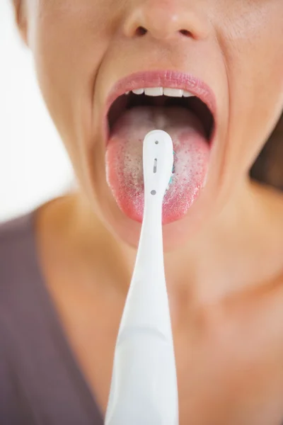 Close-up op jonge vrouw schoonmaken tong met behulp van de tandenborstel — Stockfoto