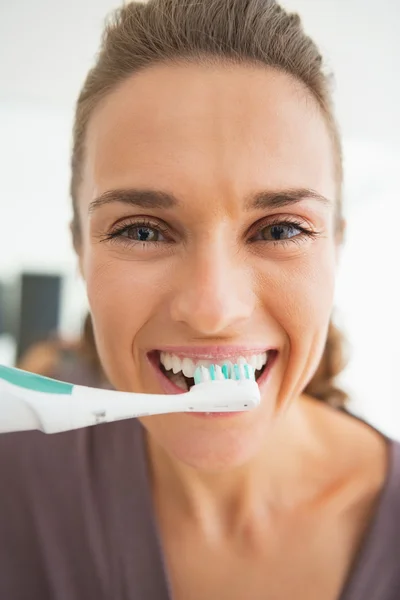 Feliz joven mujer cepillarse los dientes en el baño —  Fotos de Stock