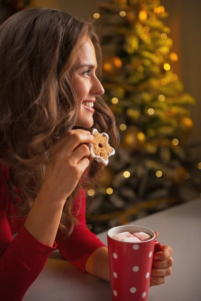 Счастливая молодая женщина с рождественским печеньем и чашкой горячего шоколада — стоковое фото