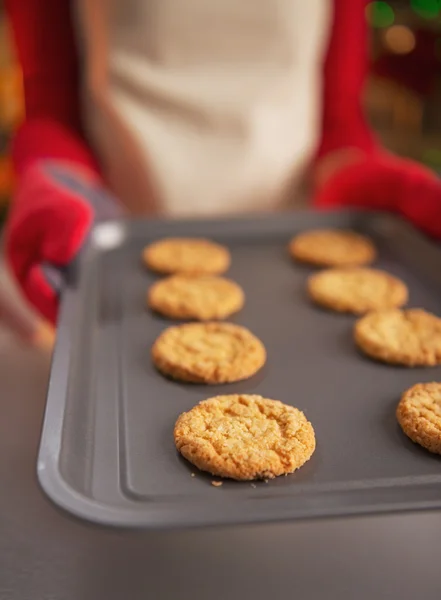 Close-up op pan met Kerstmis cookies in handen van jonge huisvrouw — Stockfoto