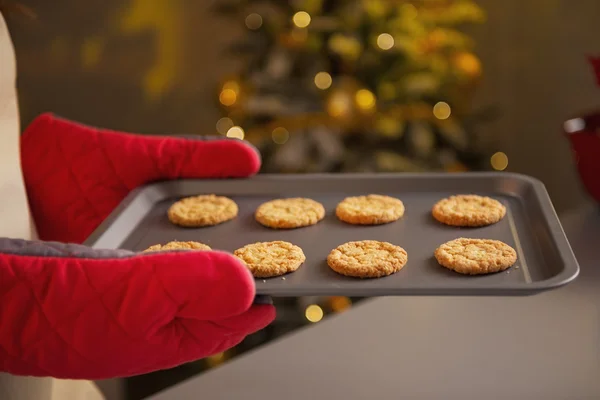 Primer plano en la sartén con galletas de Navidad en la mano de la joven ama de casa — Foto de Stock