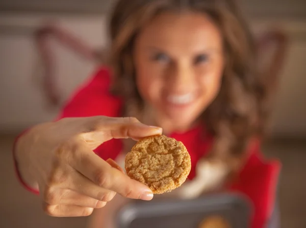 Closeup on happy young housewife showing christmas cookie — Stock Photo, Image