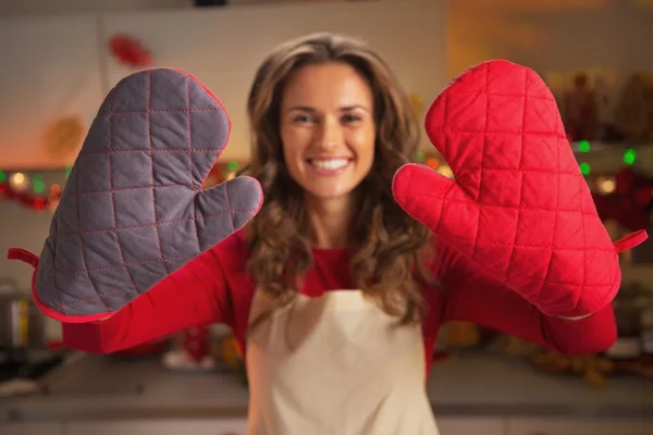Primer plano en guantes de cocina mostrando por ama de casa joven en christma — Foto de Stock