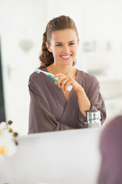 Портрет улыбающейся молодой женщины с зубной щеткой — стоковое фото