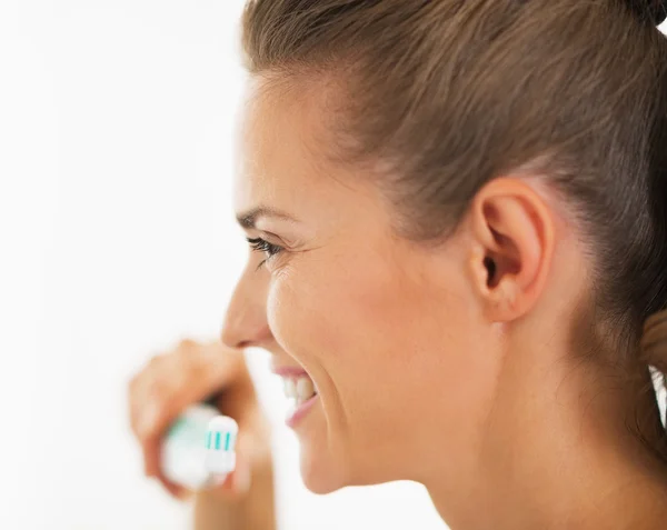 Jeune femme souriante tenant une brosse à dents avec du dentifrice — Photo