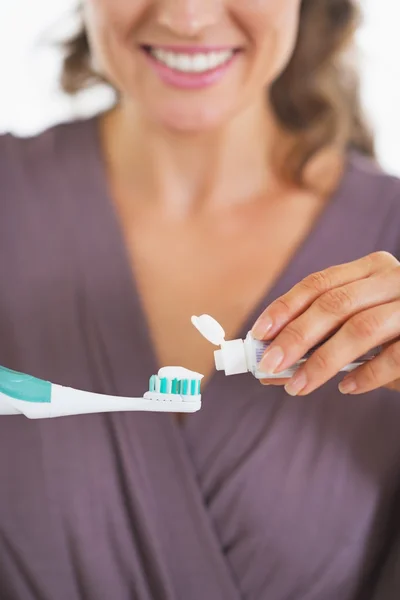 Close-up em jovem mulher espremendo pasta de dentes de tubo — Fotografia de Stock